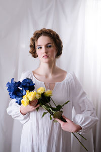 Ukrainian woman with blue yellow flowers in white