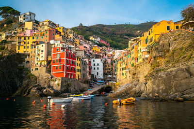 Boats in sea against buildings in city