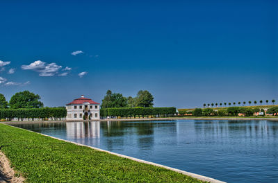 Building by river against blue sky