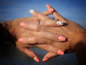 Cropped image of woman with hands clasped showing nail art