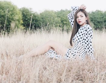 Portrait of woman sitting on field