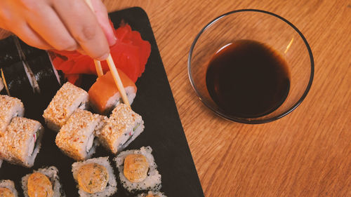 Cropped hand of person preparing food on table