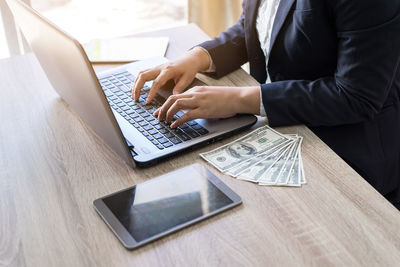 Midsection of man using laptop on table