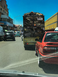 Cars on road in city against sky