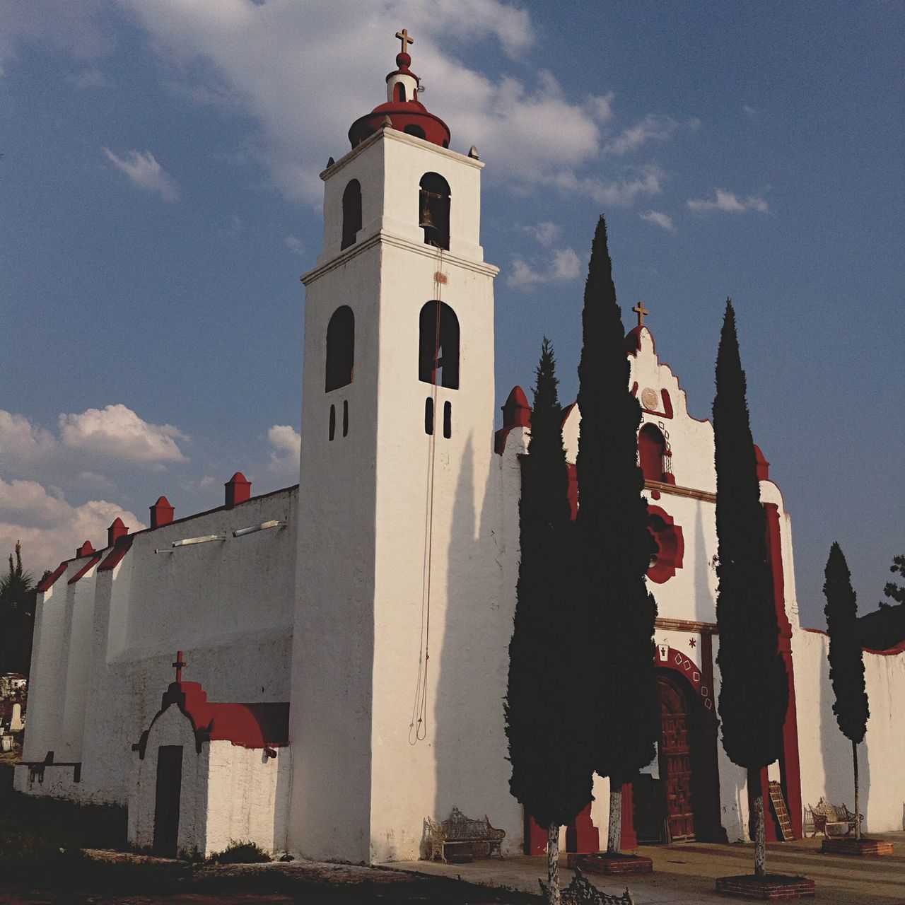 building exterior, architecture, built structure, sky, low angle view, religion, place of worship, cloud - sky, spirituality, church, cloud, history, flag, outdoors, day, famous place, tower, travel destinations, cloudy