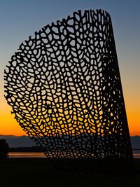 Close-up of silhouette metal against sky during sunset