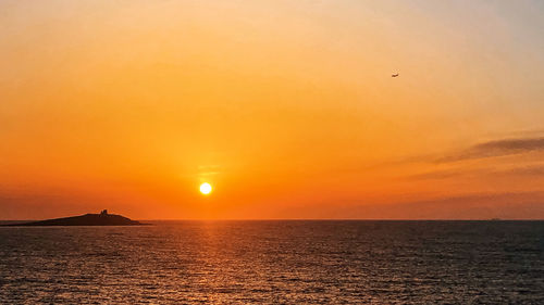 Scenic view of sea against orange sky