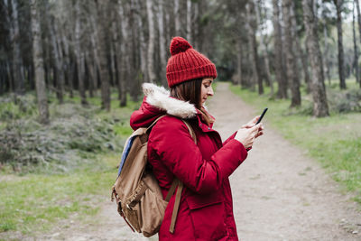 Woman with umbrella on road in forest