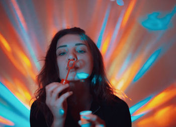 Portrait of a young woman drinking glass