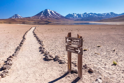 Information sign on desert against sky