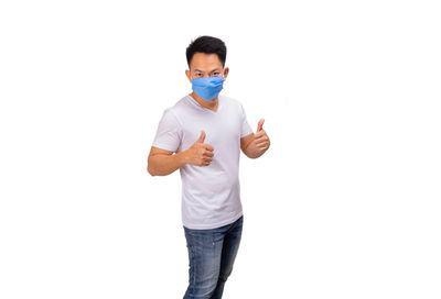 Portrait of young man standing against white background