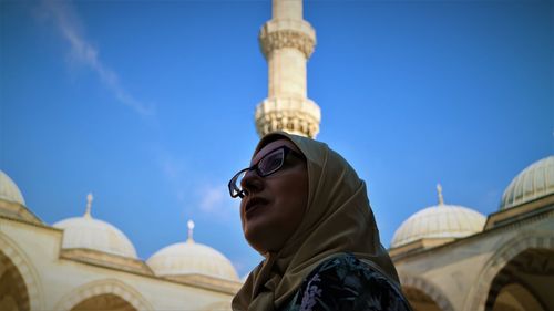 Low angle view of woman at mosque against sky