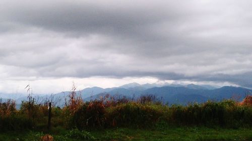 Scenic view of mountains against cloudy sky