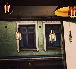 Low angle view of illuminated light hanging from window