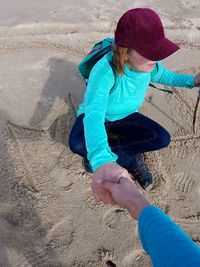 High angle view of young woman on sand