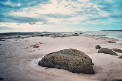 Scenic view of rocks on beach against sky