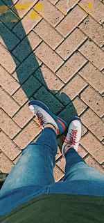 Low section of woman standing on footpath