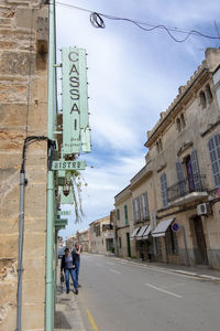 People on street against buildings in city