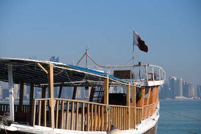 Built structure on pier by sea against clear blue sky