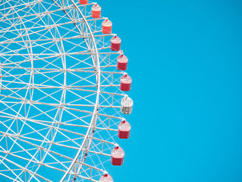 Low angle view of ferris wheel against blue sky