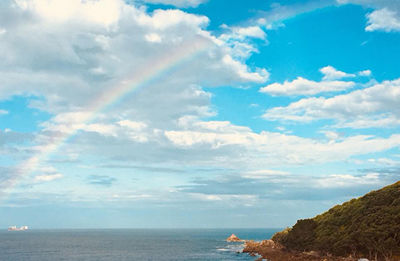 Scenic view of sea against rainbow in sky