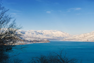Charvak reservoir with blue water in uzbekistan, surrounded by snow-capped mountain