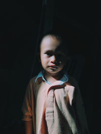 Portrait of boy standing in darkroom