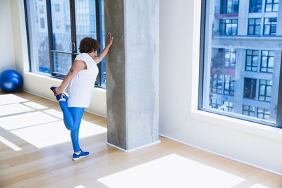 High angle view of woman stretching legs in yoga studio