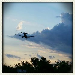 Airplane flying over cloudy sky