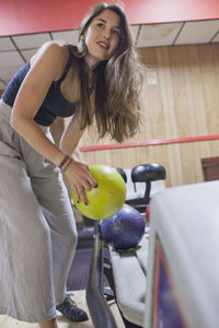 A young woman bowling.