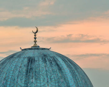 High section of mosque against cloudy sky