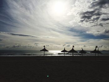 Scenic view of beach against cloudy sky