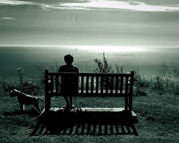 Rear view of man overlooking calm sea