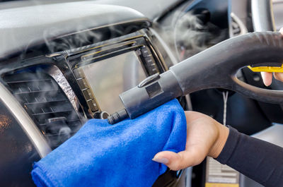 Cropped hand cleaning car air conditioner