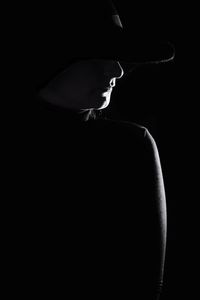 Close-up portrait of silhouette woman against black background