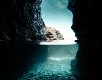 Rock formation in sea against sky