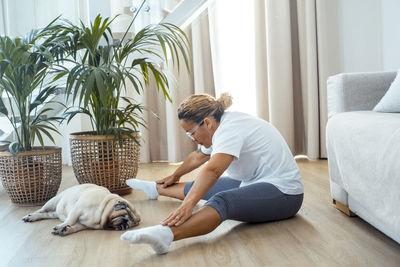 Side view of boy with dog at home