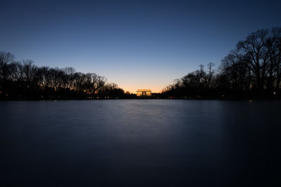 Scenic view of lake against clear sky during sunset