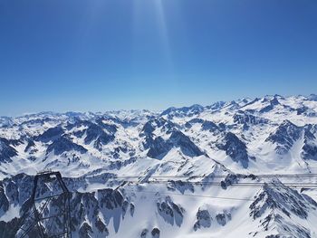 Scenic view of snowcapped mountains against clear blue sky