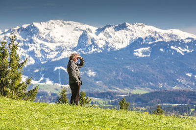 Man standing on field against mountains