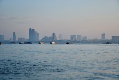 Scenic view of sea by buildings against sky