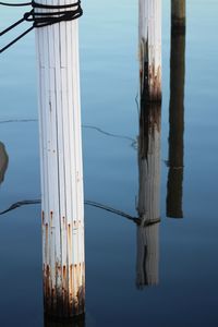 Close-up of wooden post in lake against sky