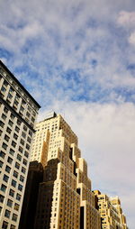 Low angle view of buildings against cloudy sky