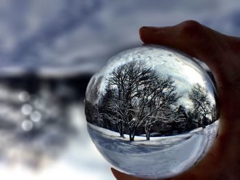 Close-up of hand against sky