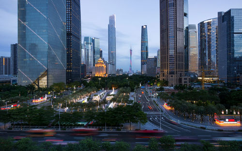 Modern buildings in city against sky at dusk