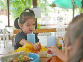 Portrait of boy holding ice cream in restaurant