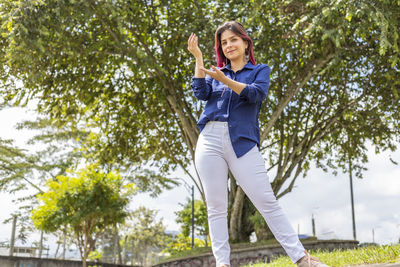 Full length of young woman standing in park