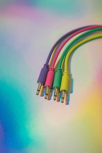 Close up of bright colored patch cables on a rainbow background