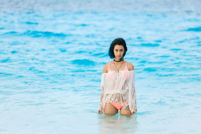 Portrait of young woman in sea against sky