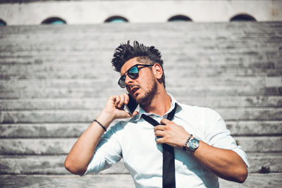 Portrait of young man wearing sunglasses standing outdoors